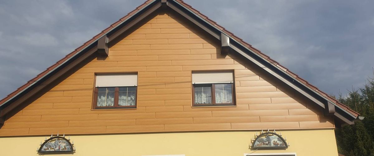 Giebel eines Wohnhauses mit neuer Verkleidung in Holzoptik
