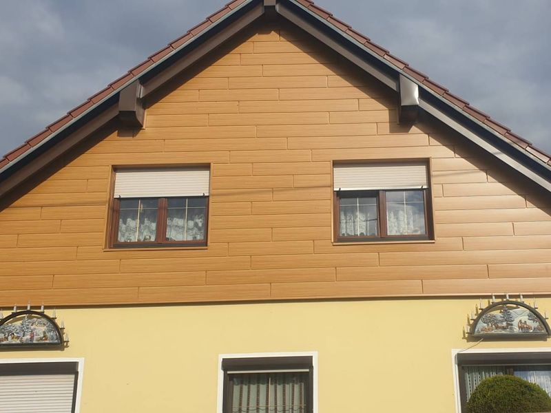 Giebel eines Wohnhauses mit neuer Verkleidung in Holzoptik